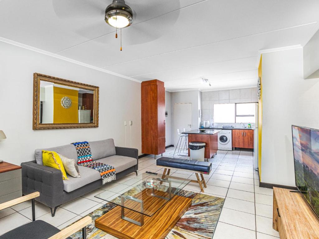 a living room with a couch and a table at Sunninghill Spacious Executive Condo in Sandton