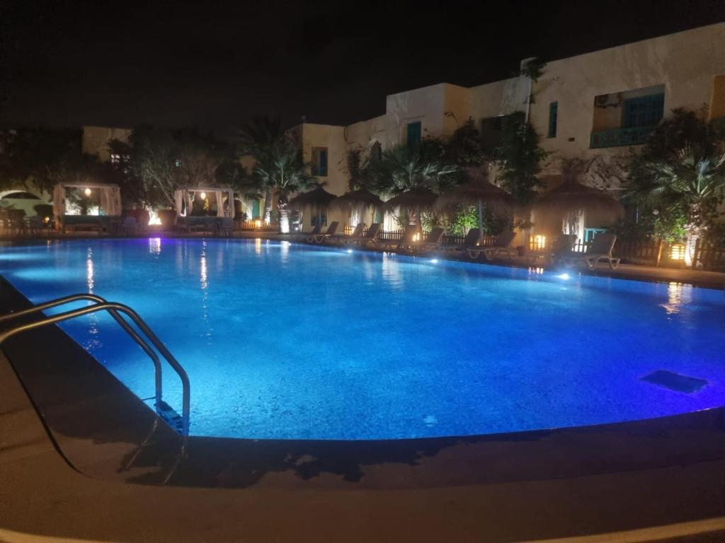 a large swimming pool at night with a slide at Hotel Diar Yassine in Midoun