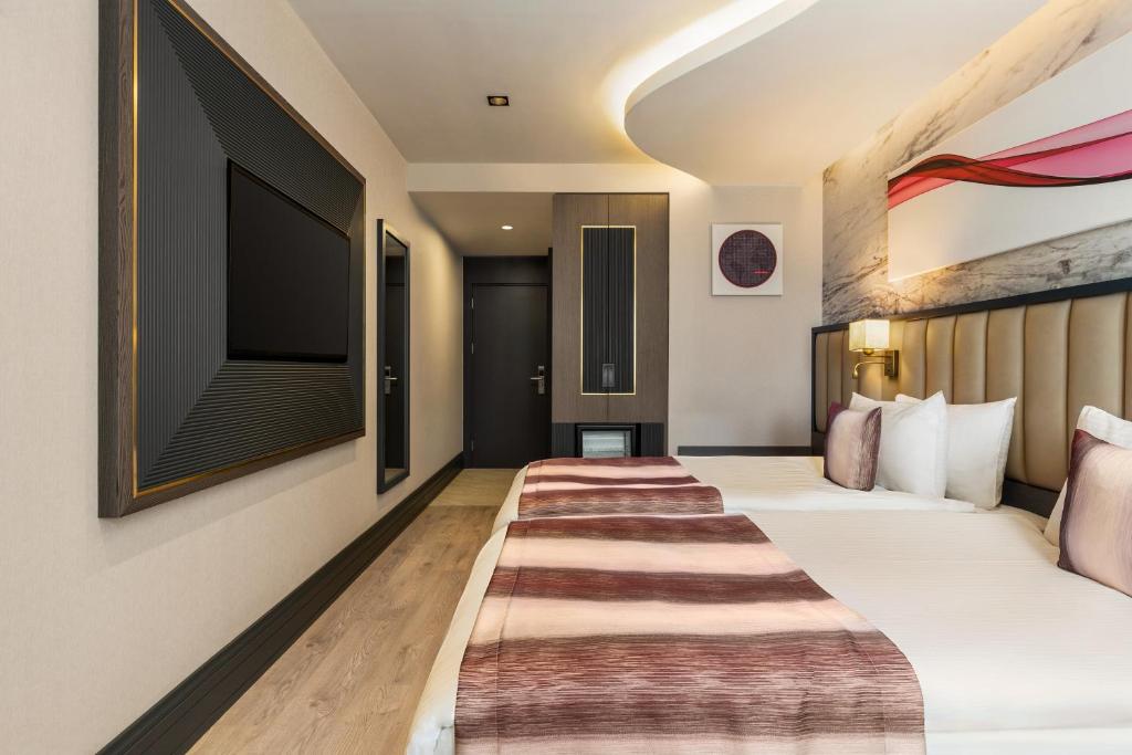 a hotel room with a bed and a flat screen tv at Ramada by Wyndham Istanbul Umraniye in Istanbul