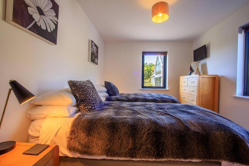 a bedroom with a bed and a desk with a lamp at Stac Polly Lodge in Achiltibuie