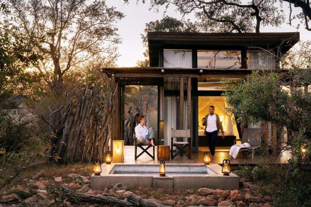 Ein Paar steht vor einem Haus. in der Unterkunft Simbavati River Lodge in Timbavati Game Reserve