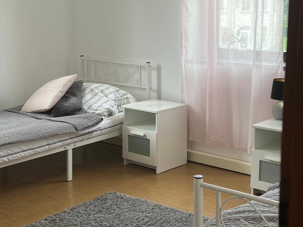 um quarto com uma cama, uma mesa e uma janela em Wolke 7 em Freital