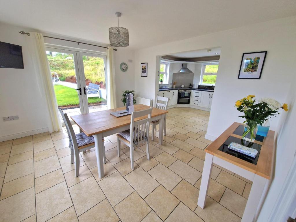 a kitchen and dining room with a table and chairs at GlenVista Holiday Accommodation in Glenariff