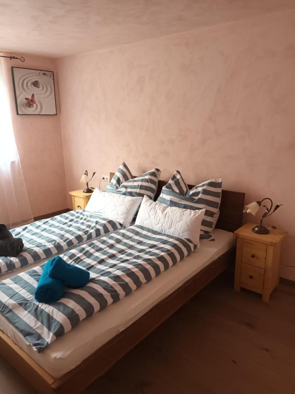 1 cama con sábanas a rayas y almohadas en una habitación en Musik und Theater Gasthof Rössle - Rooms for Angels, en Burladingen