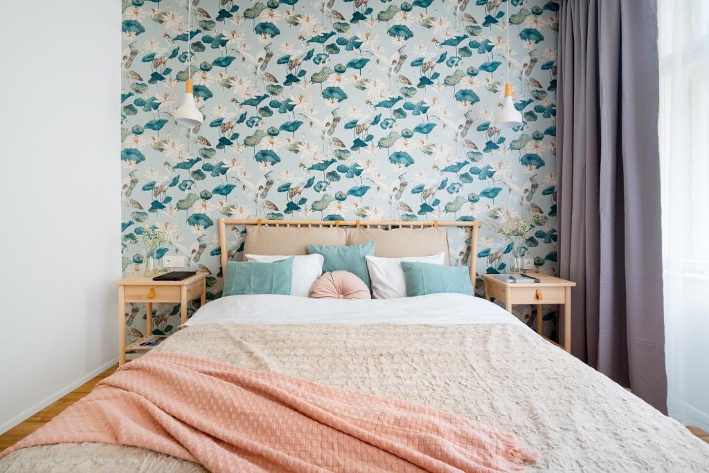een slaapkamer met een bed met bloemenbehang bij Enjoy Downtown Boutique Apartments #13 by Goodnite cz in Brno