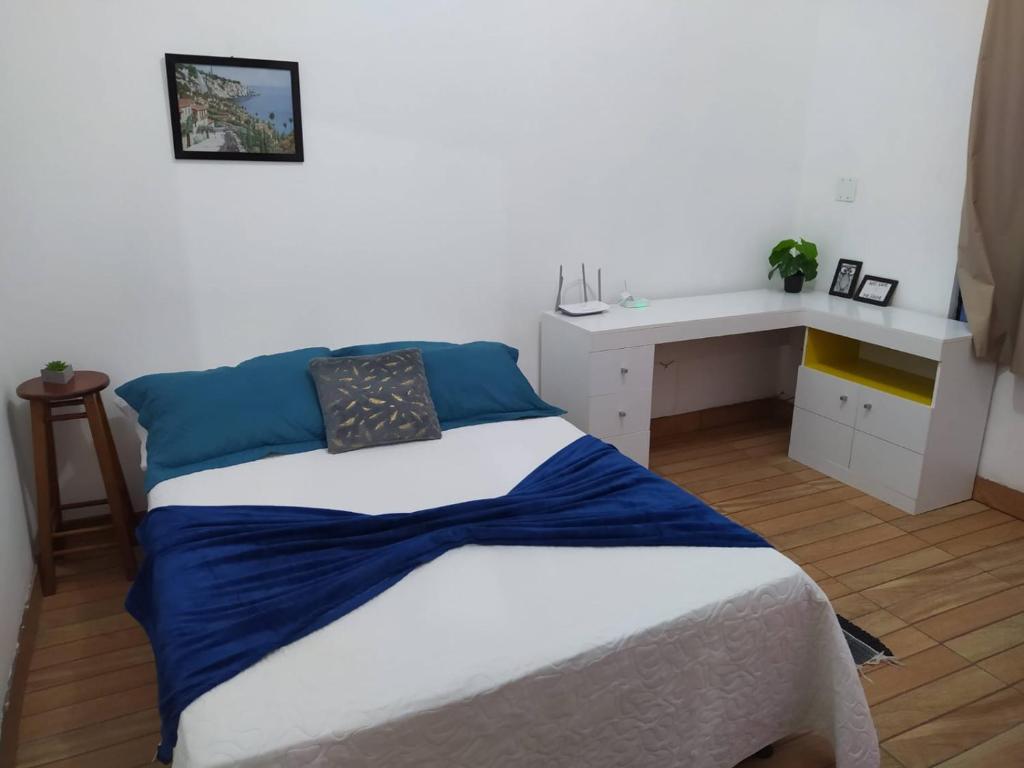 a bedroom with a bed and a white desk at Vista da Lagoa in Imbituba
