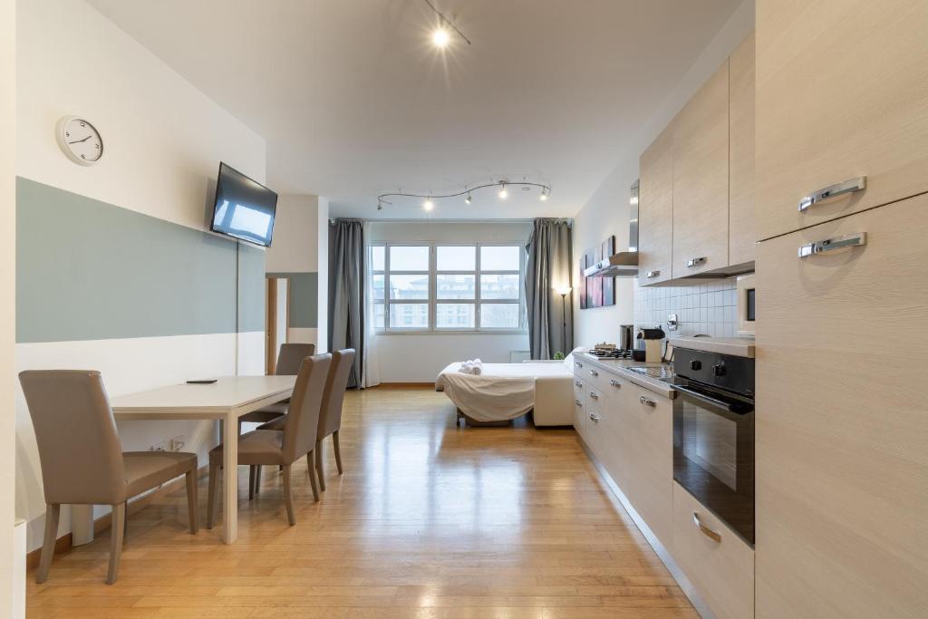 a kitchen and dining room with a table and a dining room at 4 Star Family & Friends Apt - Self Check-in in Bologna