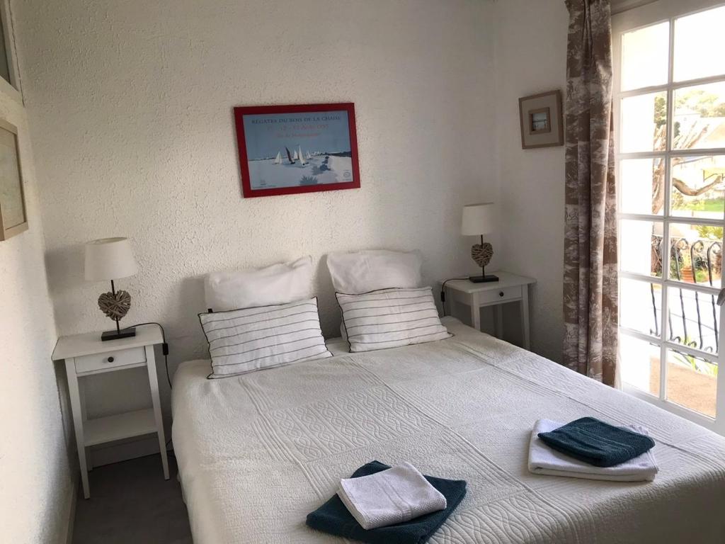 1 dormitorio con 1 cama con 2 toallas en La Gardinière, en La Barre-de-Monts