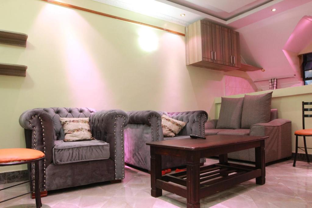 a living room with a couch and a table at Zedek Furnished Apartment 301 in Nairobi