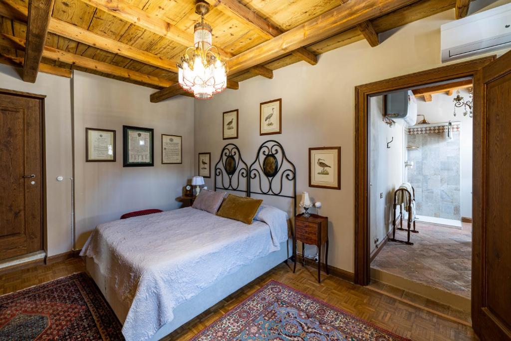 una camera con letto e lampadario a braccio di B&B Formigola a Corticelle Pieve