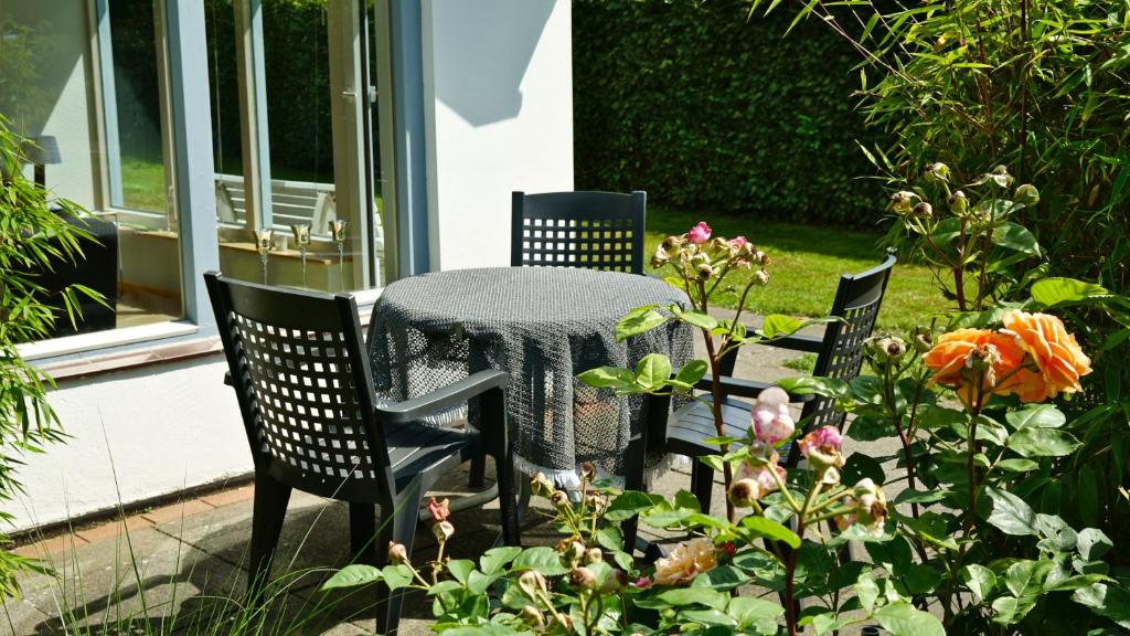 uma mesa e cadeiras sentadas num pátio com flores em Geel Hus em Brodersby