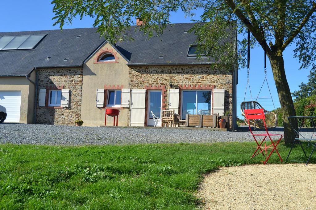 ein Haus mit einem roten Stuhl davor in der Unterkunft Gite sublime campagne in La Baconnière