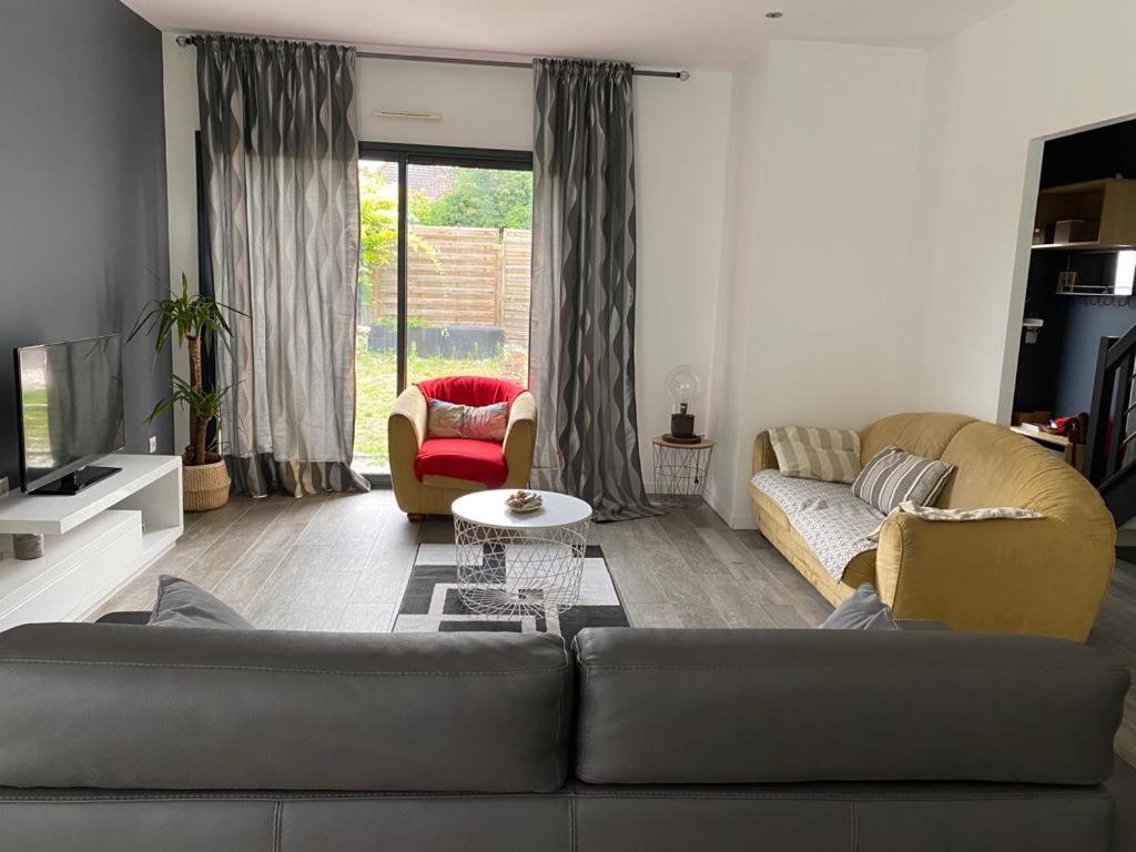 un salon avec un canapé, des chaises et une télévision dans l'établissement Villa élégante et chaleureuse proche de Paris, à La Frette-sur-Seine