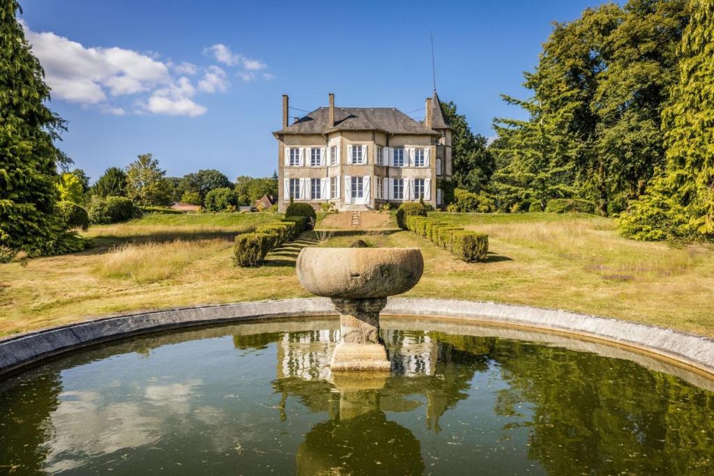 an estate with a fountain in front of a house at Le petit chateau in Vicq-sur-Breuilh