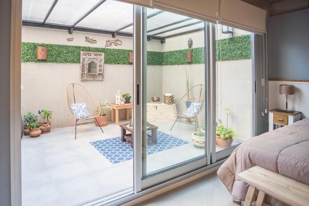 a bedroom with a bed and a sliding glass door at El Patio Suites en Palermo Hollywood in Buenos Aires