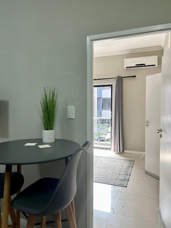 a dining room with a table and two chairs at Meridian Suite Apartments in Umhlanga Ridge in Durban