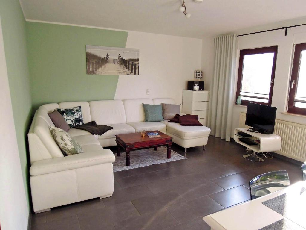 sala de estar con sofá blanco y TV en Haus Zeitlos, en Zingst