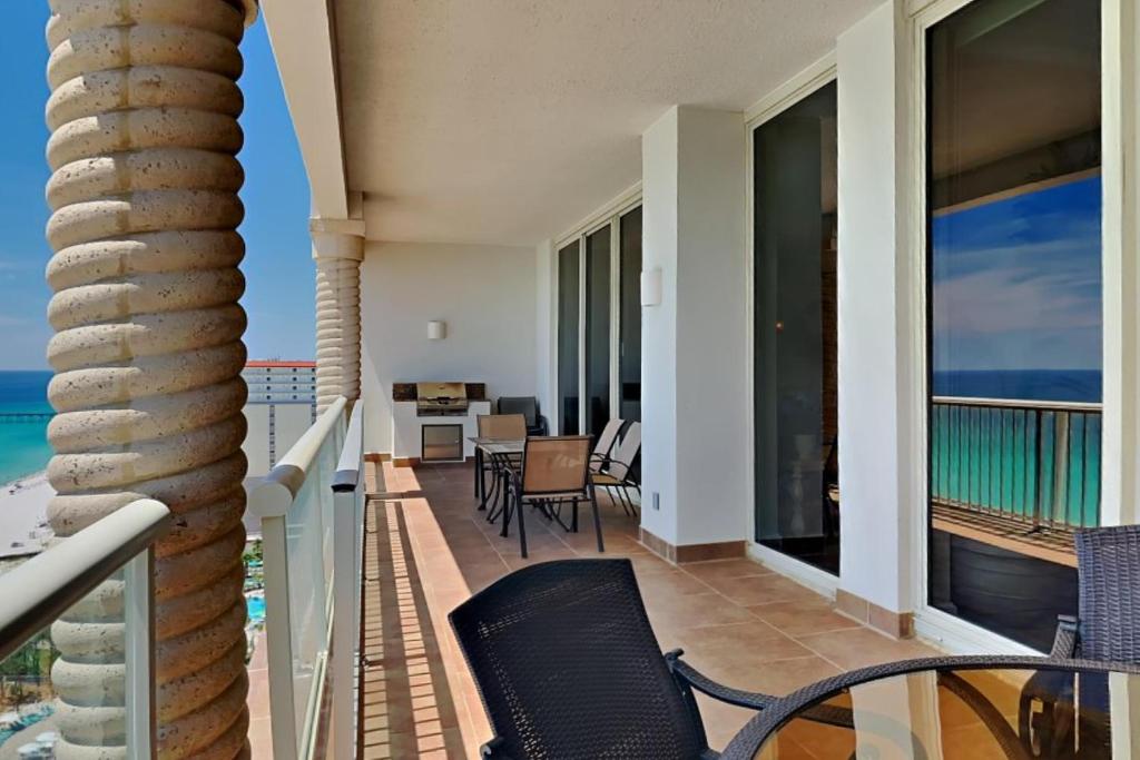 Un balcón con sillas y vista al mar. en Beach Club #1804C, en Pensacola Beach