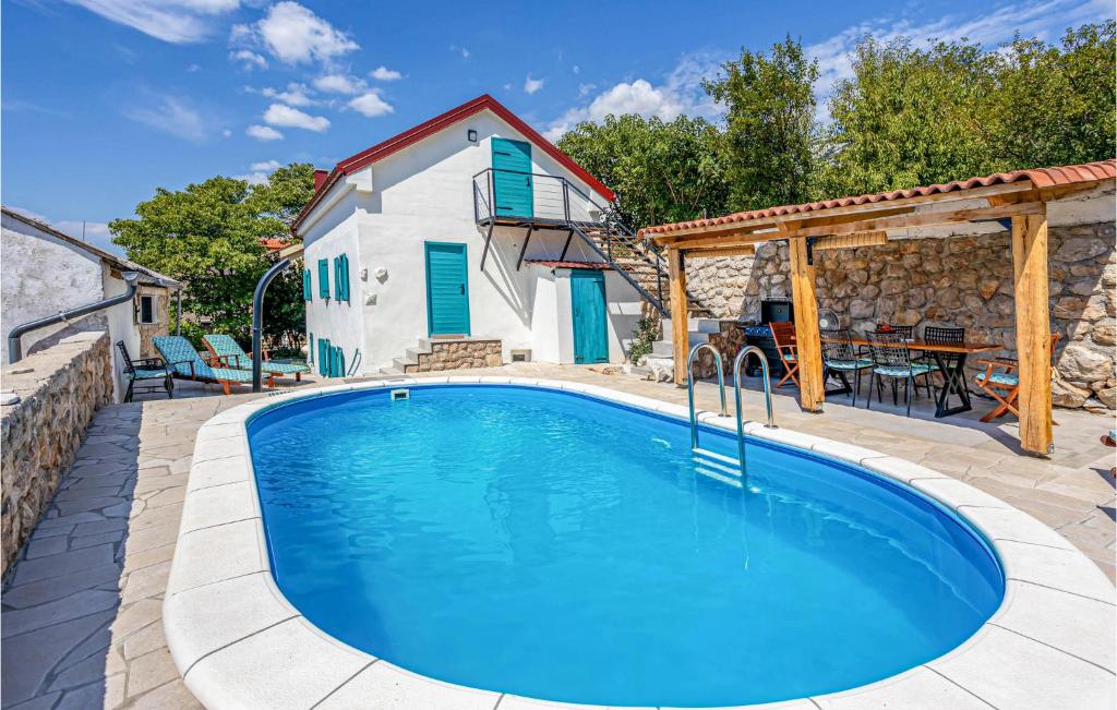 a swimming pool in front of a house at 3 Bedroom Awesome Home In Karlobag in Karlobag