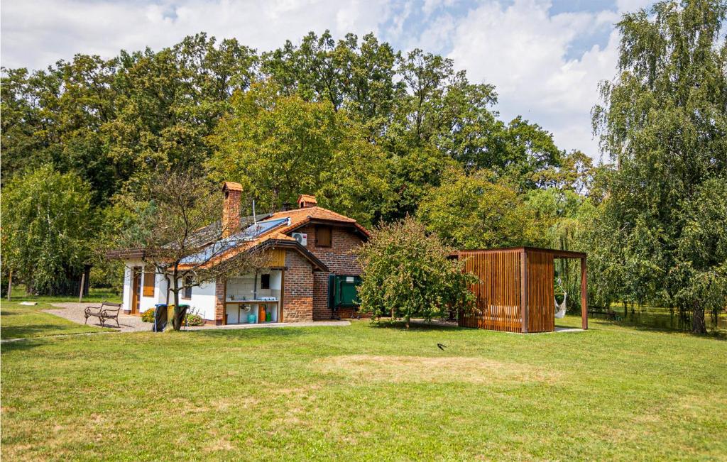 une petite maison dans une cour herbeuse avec un hangar dans l'établissement Awesome Home In Rokovci With House A Panoramic View, 