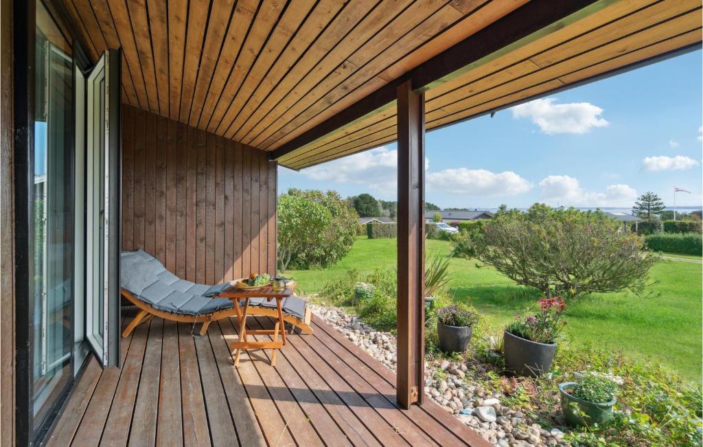 a wooden deck with a chair and a table at Gorgeous Home In Kalundborg With Wifi in Kalundborg