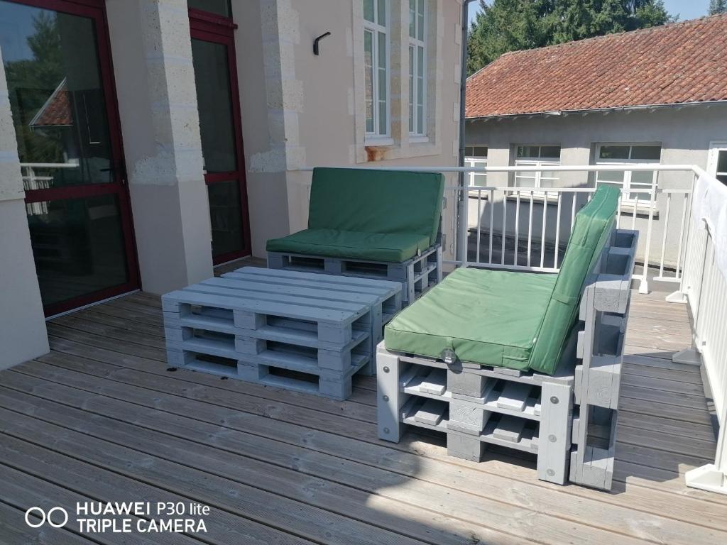 ein Paar Stühle und eine Bank auf einem Deck in der Unterkunft Gite d'Etape de Chirac in Chirac