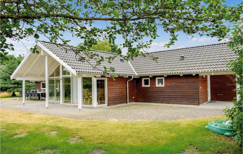 een houten huis met een grote patio bij Stunning Home In Ebeltoft With Wifi in Ebeltoft