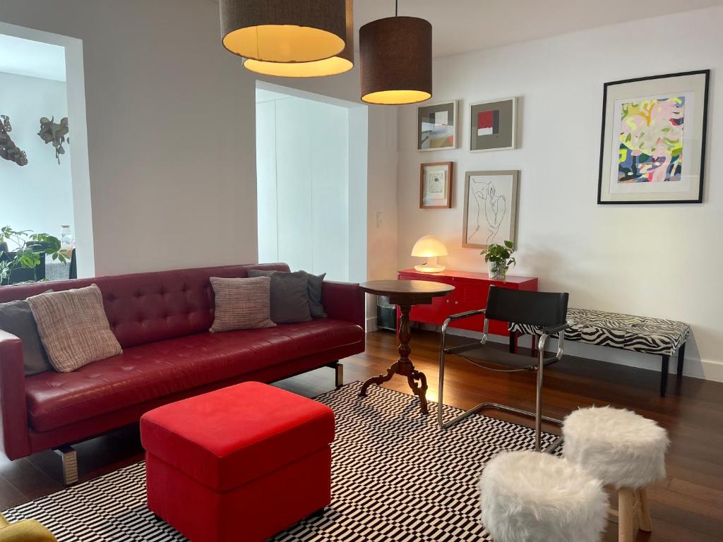 sala de estar con sofá rojo y taburete rojo en Casa Amiluz, en Ponta Delgada