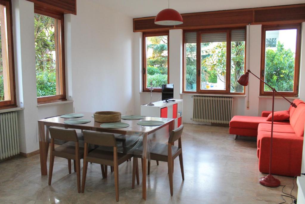 un soggiorno con tavolo e divano rosso di Lilly's Home a Castelfranco Veneto