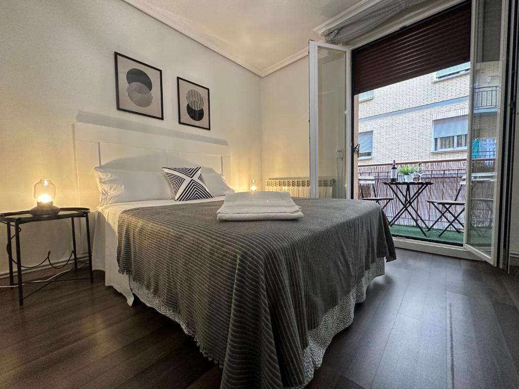 a bedroom with a bed and a large window at Apartamento Palacio de Justicia in Logroño