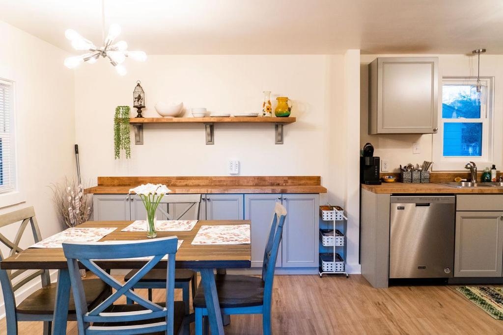 チャールストンにあるMadrona's Guesthouse- Convenient location, pet friendlyのキッチン(木製テーブル、青い椅子付)