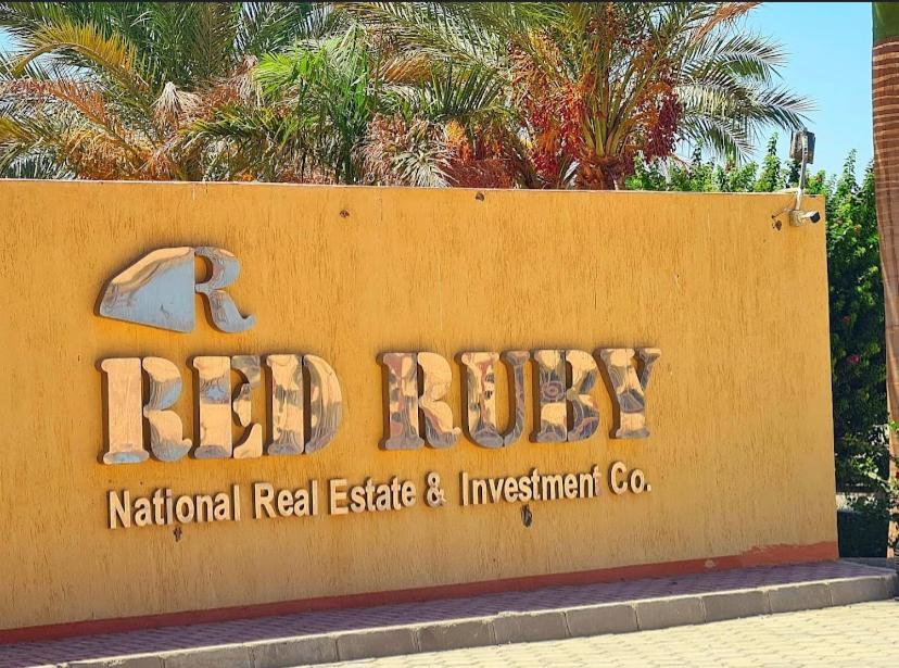 a sign for a ritzvisornatural real estate and investment company at منتجع الياقوتة الحمراء in Hurghada