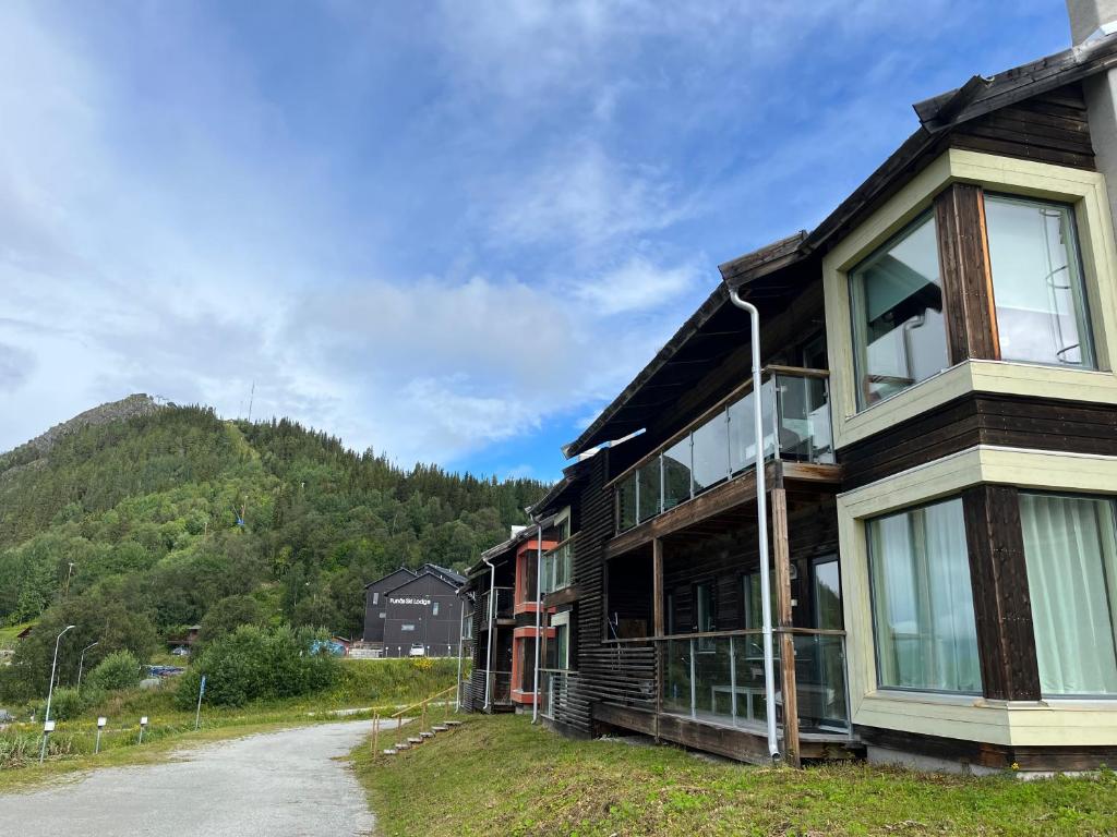 a wooden house with a mountain in the background at Ski Village Funäsdalen in Funäsdalen