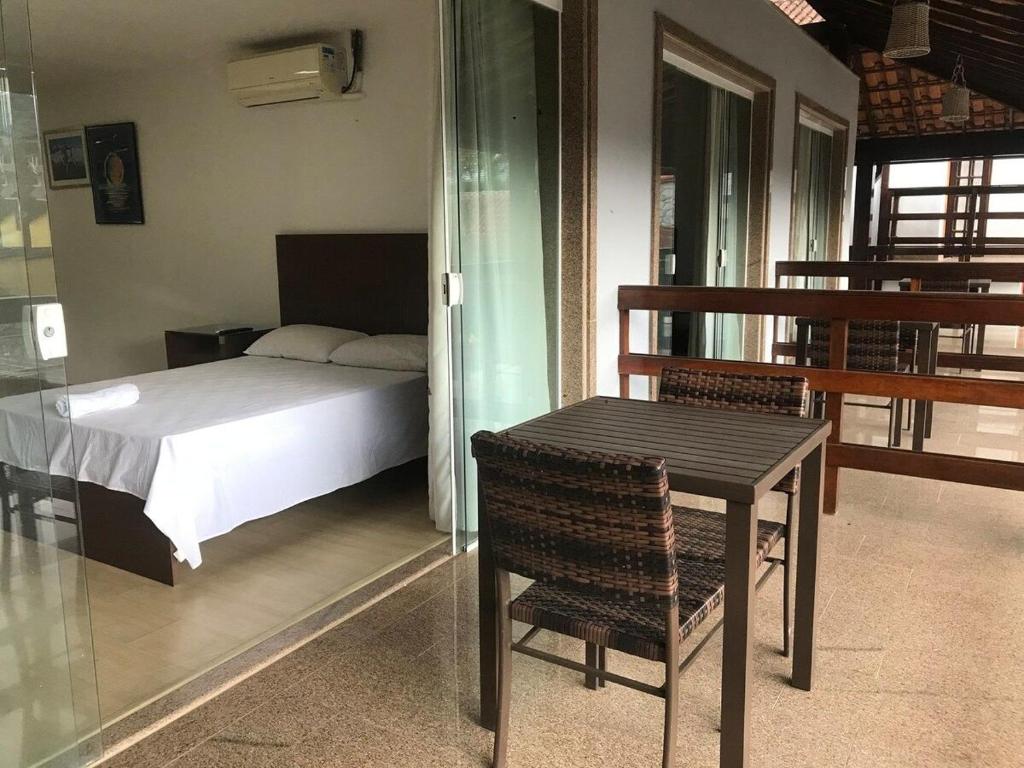 1 dormitorio con 1 cama, mesa y silla en Casa com piscina e sauna em Petrópolis en Petrópolis