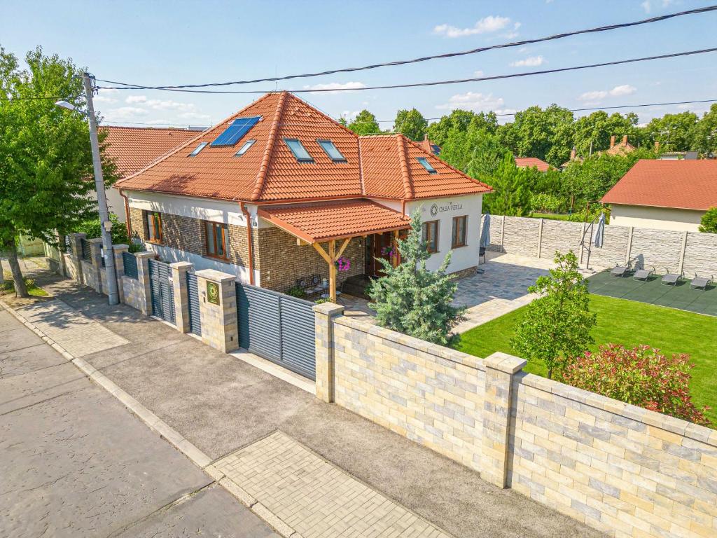ein Haus mit einem Kacheldach und einem Zaun in der Unterkunft Casa PERLA in Dunajská Streda