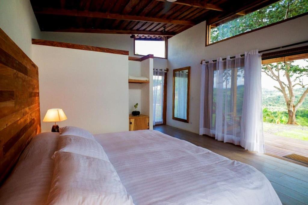 a bedroom with a large bed and a large window at Luxury Villa Carao. Jungle Paradise. Amazing Views. Great wifi! in San Mateo