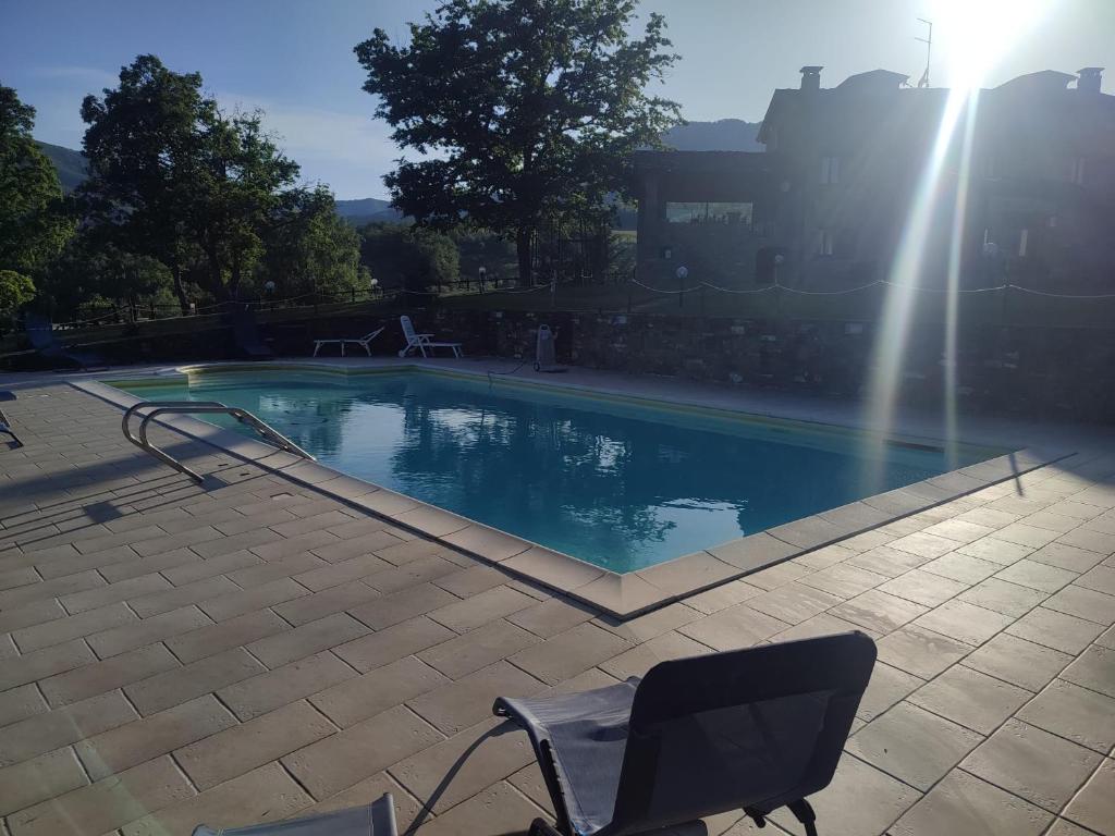 una piscina con una silla y una fuente en Casa Vacanze Fattoria il Cerro en Pianelleto