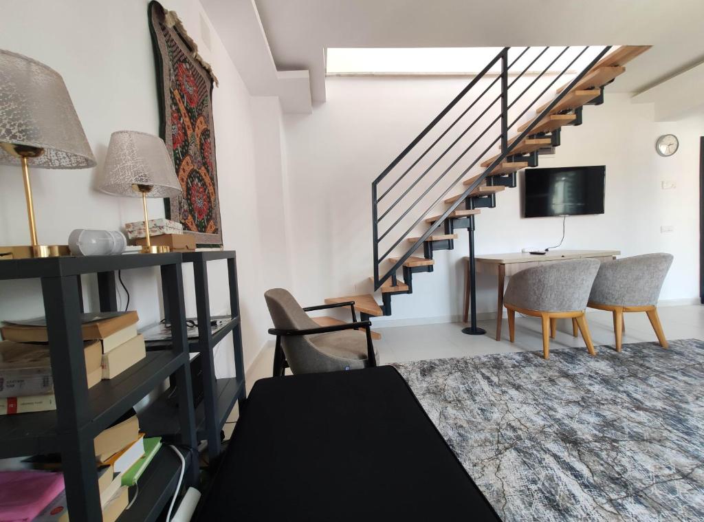 een woonkamer met een trap en een tafel en stoelen bij Denizolgun Homes Tenim Suit Apart 3 in Dalaman