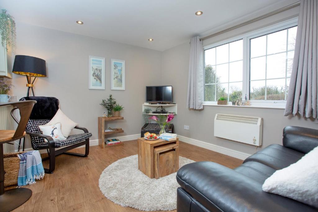 ein Wohnzimmer mit Sofa und Tisch in der Unterkunft Puffin Leigh Cottages in Seaton