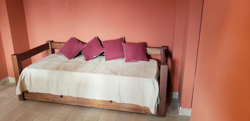 Un dormitorio con una cama con almohadas moradas. en Espacio 20 de febrero en Salta