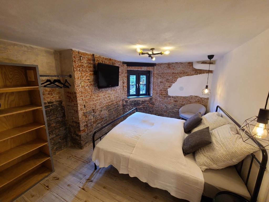 a bedroom with a bed and a brick wall at Apartment 22 in Coburg