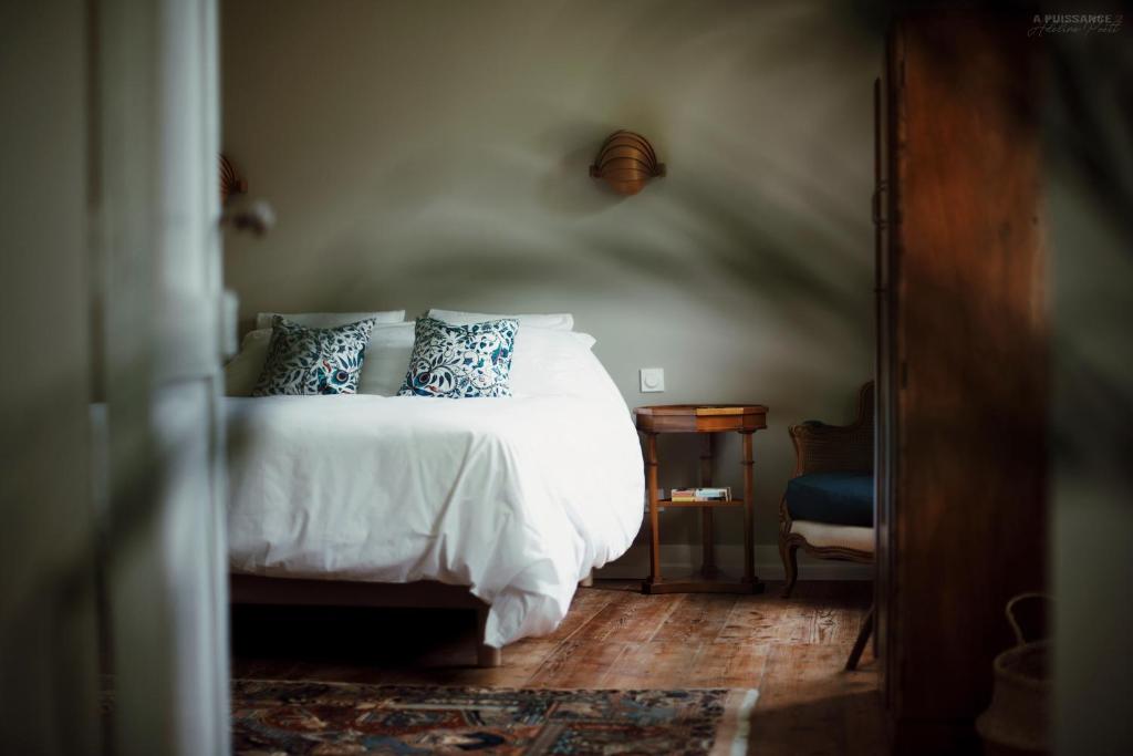 1 dormitorio con cama blanca y almohadas azules en Château Le Repos, en Rouffignac-de-Sigoulès