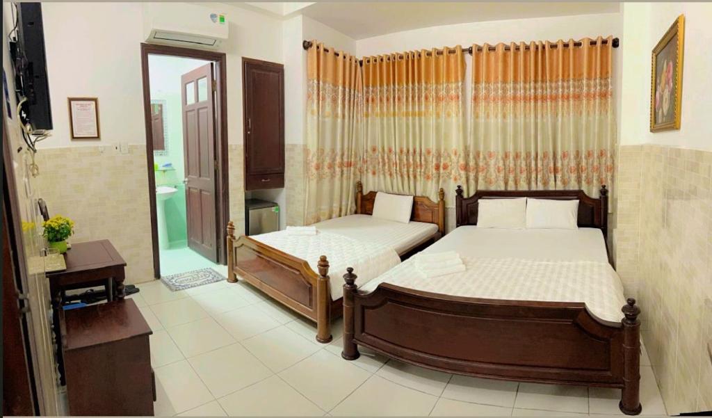 a bedroom with two beds and a mirror at HƯƠNG LAN HOTEL in Ho Chi Minh City