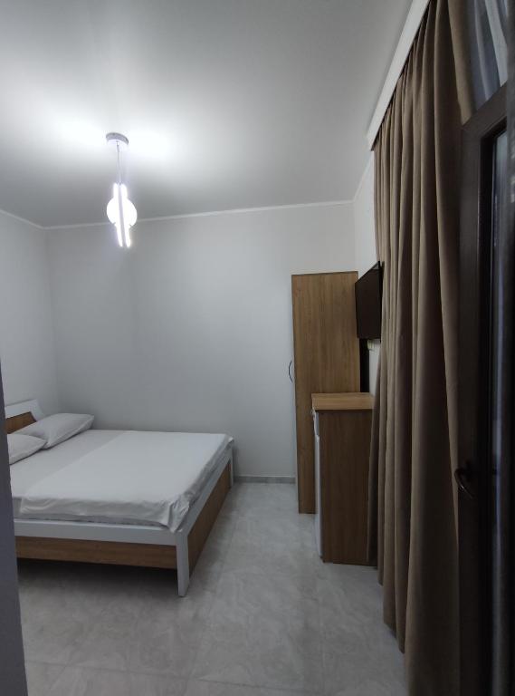 a small bedroom with a bed and a curtain at The best guest house-GAIOZ in Gonio