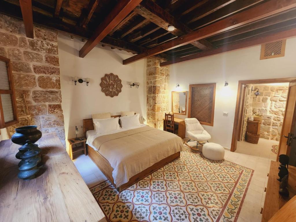 a bedroom with a bed and a chair in a room at Suzanne Suite in ‘Akko