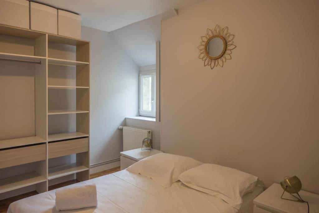 a bedroom with a bed and a mirror on the wall at Coeur de Blois Maison T3 in Blois