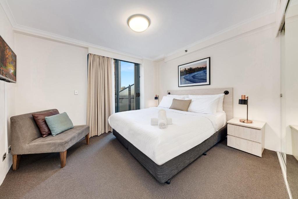um quarto com uma cama grande e uma cadeira em Comfy and Spacious 1B Sydney CBD Apartment in Central em Sydney