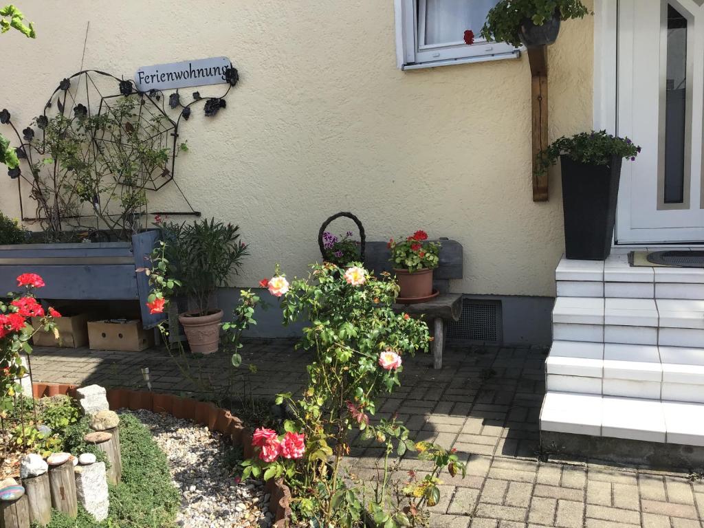 un giardino con fiori e piante di fronte a una casa di Ferienwohnung Roth a Memmingen
