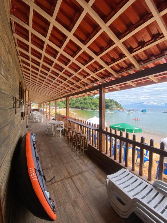 a room with a boat on a balcony with a view of the beach at Pousada Frezza Mergulho in Praia Vermelha