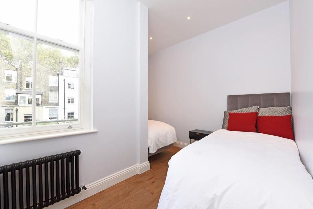 a bedroom with a white bed and a window at Sleep8 Buckingham Palace Bigben with AC VB4 in London